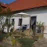Ferienwohnungen Seitner, © Beatrix Seitner Ein weißes Haus mit rotem Dach, Garten und Sonnenschirm.