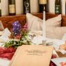 Old shipmaster's house, © Best of Wachau_Rita Newman Elegant table setting with menu, candle, flowers and bottles of wine in the background.