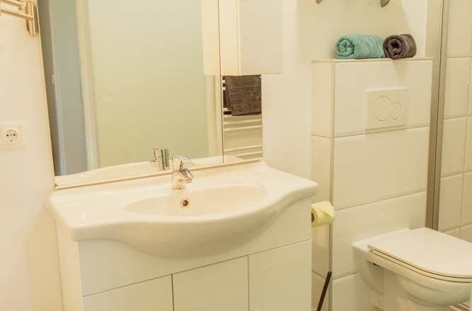 Appartement 1, © Ines Nejedly Modernes Badezimmer mit Waschbecken, Spiegel, Toilette und Regalen.