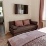 Apartment 1, © Ines Nejedly Modern living room with sofa, flat screen TV and window with pink curtains.