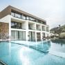Boutiquehotel "Das WeinSpitz", © © photography_pfeffel_at Modernes Boutiquehotel mit Pool und Liegestühlen, umgeben von grüner Landschaft.