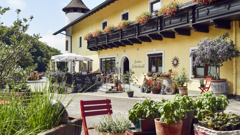 Wirtshaus mit Christbaumkultur, © Niederösterreich Werbung/Andreas Hofer Gemütliches Gasthaus mit Blumenschmuck und Terrasse, ländliche Atmosphäre.