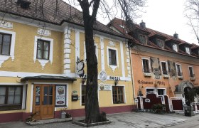 Exterior view, © Donau NÖ Exterior view of a yellow building with restaurant and hotel, tree in the foreground.