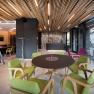 Boutiquehotel "Das WeinSpitz", © © photography_pfeffel_at Innenansicht einer modernen Hotel-Lounge mit Holzelementen, grünen und lila Stühlen und einem runden Tisch.