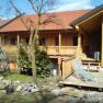 Pferdehof Kranzer, © Maria Kranzer Holzgebäude mit Terrasse und Garten im Vordergrund.