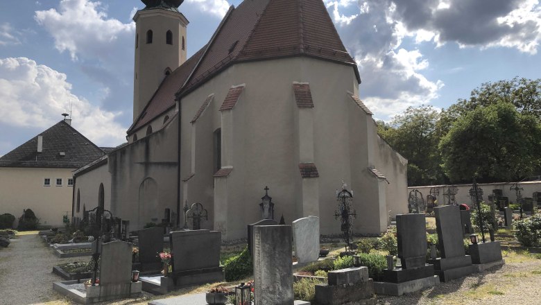 aggsbach-markt-church2, © Donau NÖ Tourismus Church with cemetery and gravestones in the foreground, cloudy sky.