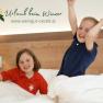 Gästezimmer, © DM Zwei Kinder spielen fröhlich in einem Bett in einem Gästezimmer.