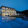 Boutique Hotel mit Pool, © photography_pfeffel Modernes Boutique-Hotel mit beleuchtetem Pool bei Nacht.