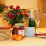 Haus Oestreicher, © Haus Oestreicher Frühstückstisch mit Brötchenkorb, Marmelade, Sektflasche und Rosen.