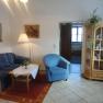 Haus König, © Fam. König Wohnzimmer mit blauer Couch, blauem Sessel, Holztisch und Vitrine.