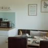 Apartment 1, © Ines Nejedly Small kitchen with coffee machine, oven, dining table and flowers.