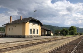 Bahnhof Aggsbach-Markt, © Donau NÖ Tourismus Bahnhof Aggsbach-Markt mit Gleisen und bewölktem Himmel.