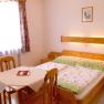 Weingut Roman Gritsch, © Gritsch Gemütliches Schlafzimmer mit Holzmöbeln, Doppelbett und kleinem Tisch.