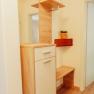 Appartement 2, © Ines Nejedly Moderner Flur mit Holzschrank, Spiegel und Pflanze.