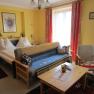 Zimmerbeispiel Haus Sundl, © Margit Siebenhandl Zimmer mit Doppelbett und Couch mit Tisch im Vordergrund