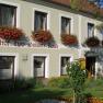 Gasthof Zur weißen Rose, © Astrid Busch Fassade eines Gasthofs mit Blumen und Schriftzug 'Gasthof zur Weißen Rose'.