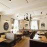 Architectural history meets modern ambience, © Niederösterreich Werbung/Michael Reidinger Modern restaurant with wooden tables, gray upholstered benches and stylish lamps.