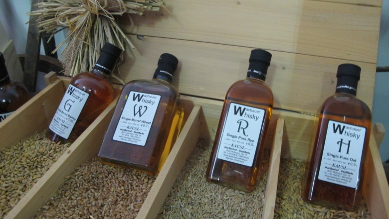 Wachau whisky, © Jutta Mucha-Zachar Bottles of Wachau whisky displayed on cereal grains.