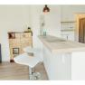 Apartment 1, © Familie Schauer Modern kitchen with bar counter, two white bar stools and an old oven.