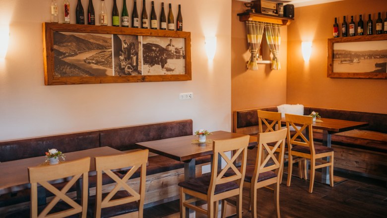 Stop off on the Danube, © Niederösterreich Werbung/Daniela Führer Cozy restaurant with wooden furniture, bottles of wine and historical photos.