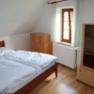 Bedroom upper floor, © Copyright A bedroom with a double bed, wooden chest of drawers and wardrobe, light-colored walls and a window with a curtain.