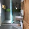 Badezimmer, © Romana Wiener Modernes Badezimmer mit Dusche, Waschbecken und blauen Duschvorhang.