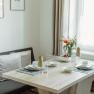 Appartement 1, © Ines Nejedly Essbereich in einem modernen Appartement mit gedecktem Tisch und Blumen.