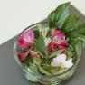 Apartment 1, © Ines Nejedly A glass jar with colorful flowers and green leaves on a table.
