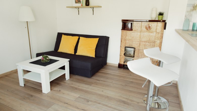 Appartement 2, © Ines Nejedly Modernes Wohnzimmer mit Sofa, Couchtisch, Barhockern und Kamin.