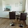 Appartement 1, © Ines Nejedly Moderne Küche mit Esstisch, Stühlen und Geräten.
