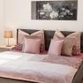 Appartement 1, © Ines Nejedly Gemütliches Schlafzimmer mit Doppelbett, rosa Bettwäsche und zwei Nachttischen mit Lampen.