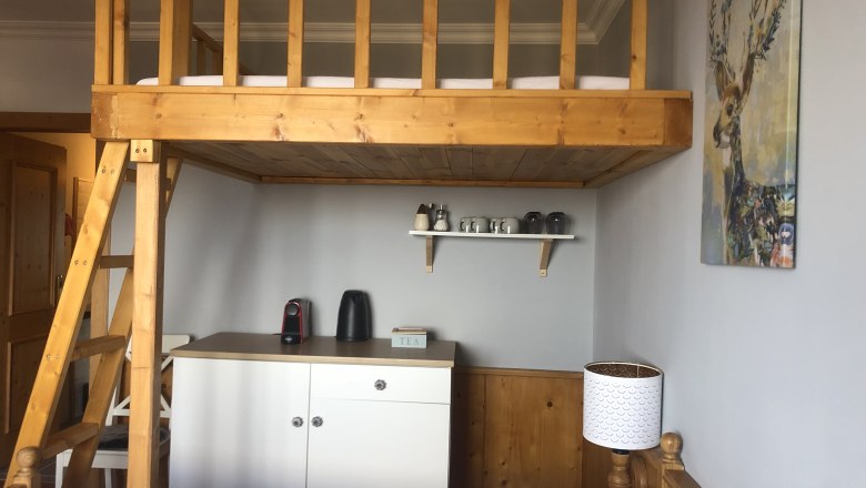Tee-Ecke im Zimmer Urlaub am Jauerling, © Romana Wiener Zimmer mit Hochbett, Teestation und Hirschbild an der Wand.