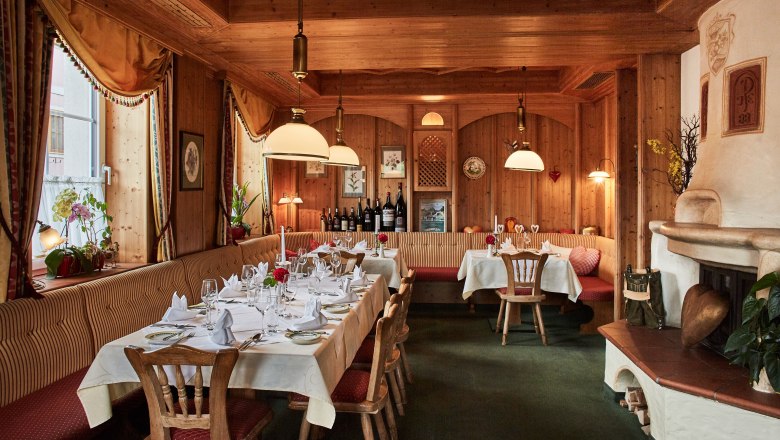 Kaminstüberl, © Familie Pichler Gemütliches Restaurant mit Holzwänden, gedeckten Tischen und Kamin.