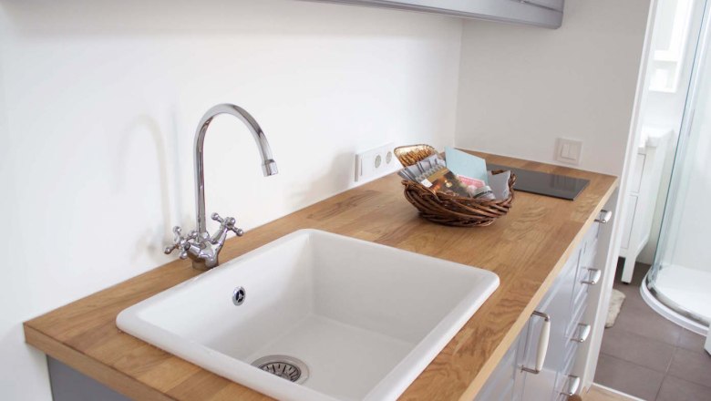 Apartment Spitz an der Donau, © Georg Gradl Modern kitchen unit with sink, wooden worktop and basket with utensils.