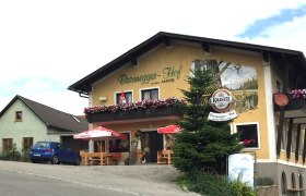 Gasthof Braunegger-Hof mit Balkonblumen und Sonnenschirmen.