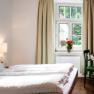 Double bed with window and table corner with TV