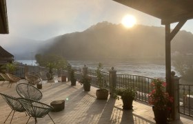 Terrace with a view of the river and mountains at sunrise.