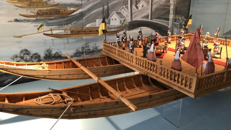 Modell eines historischen Schiffs mit Figuren in einem Museum.