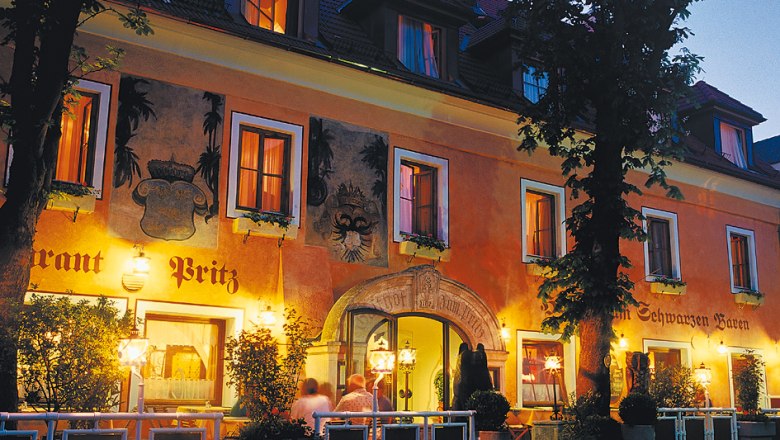 Hotel Restaurant „Zum Schwarzen Bären", © Lachlan Blair Historisches Gebäude des Hotels Zum Schwarzen Bären bei Nacht, beleuchtet mit warmem Licht.
