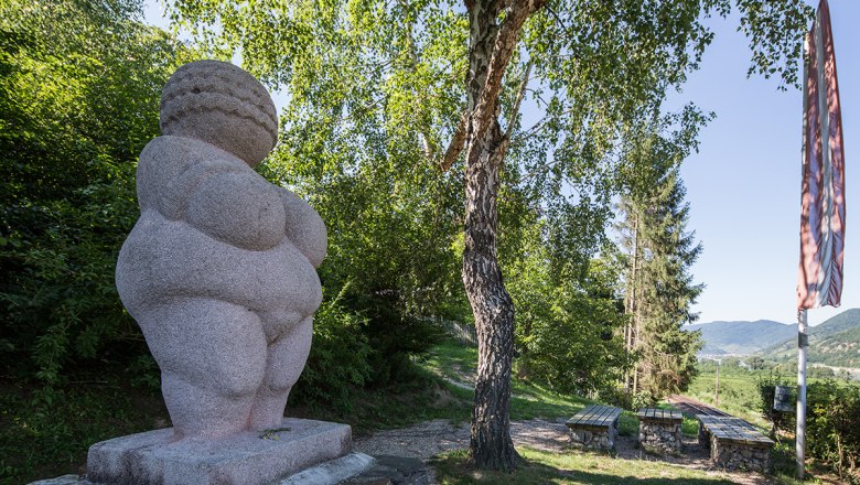 Venus on a pedestal in the background tree and benches