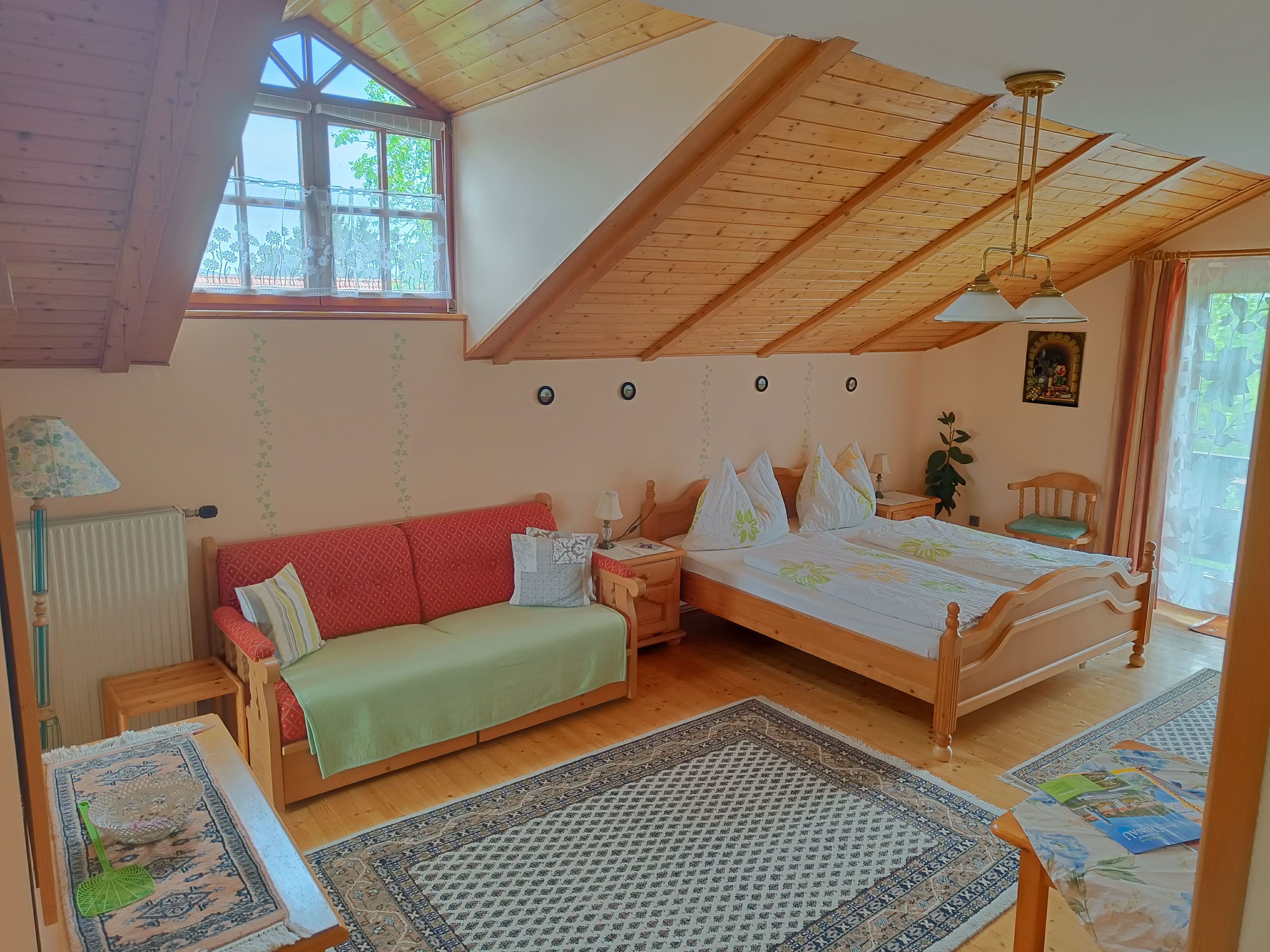 Zimmer mit Dachschräge, Doppelbett und Couch