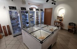 Innenraum des Hofladens mit Kühltruhen und mehreren Kühlschränken.