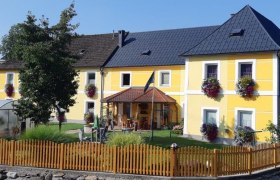 Gelbes Haus mit Garten und Holzzaun