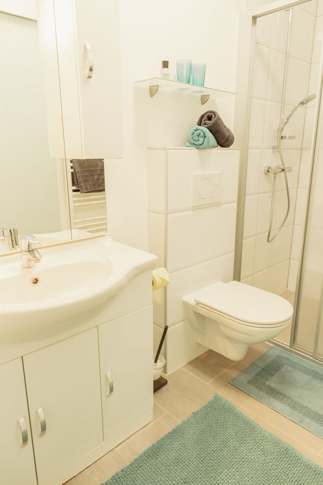 Modernes Badezimmer mit Dusche, Waschbecken und Toilette.