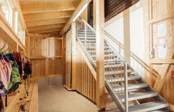 Eine Aluminiumtreppe in der Naturwerkstatt, neben ihr ist eine lange Garderobe mit Bank.