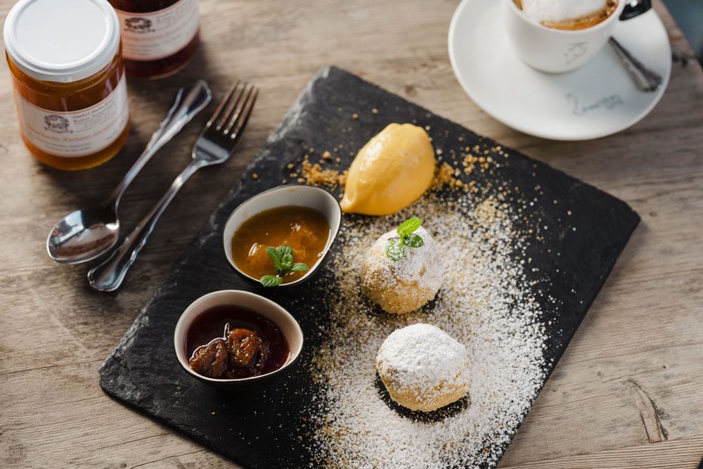 Marillenknödel mit Räster auf Schieferplatte serviert.