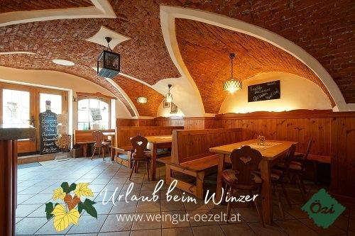 Innenansicht eines gemütlichen Heurigenlokals mit gewölbter Ziegeldecke und Holzmöbeln.