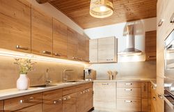 Eine moderne Küche in Holzoptik mit weicher Beleuchtung.