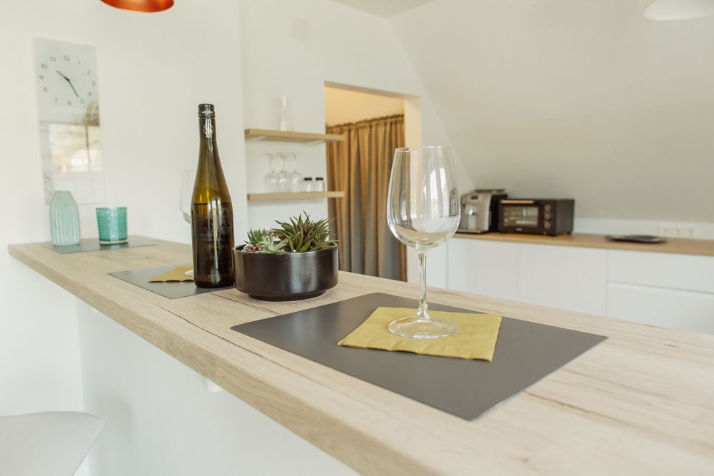 Moderne Küche mit Bartresen, Weinglas und Flasche.