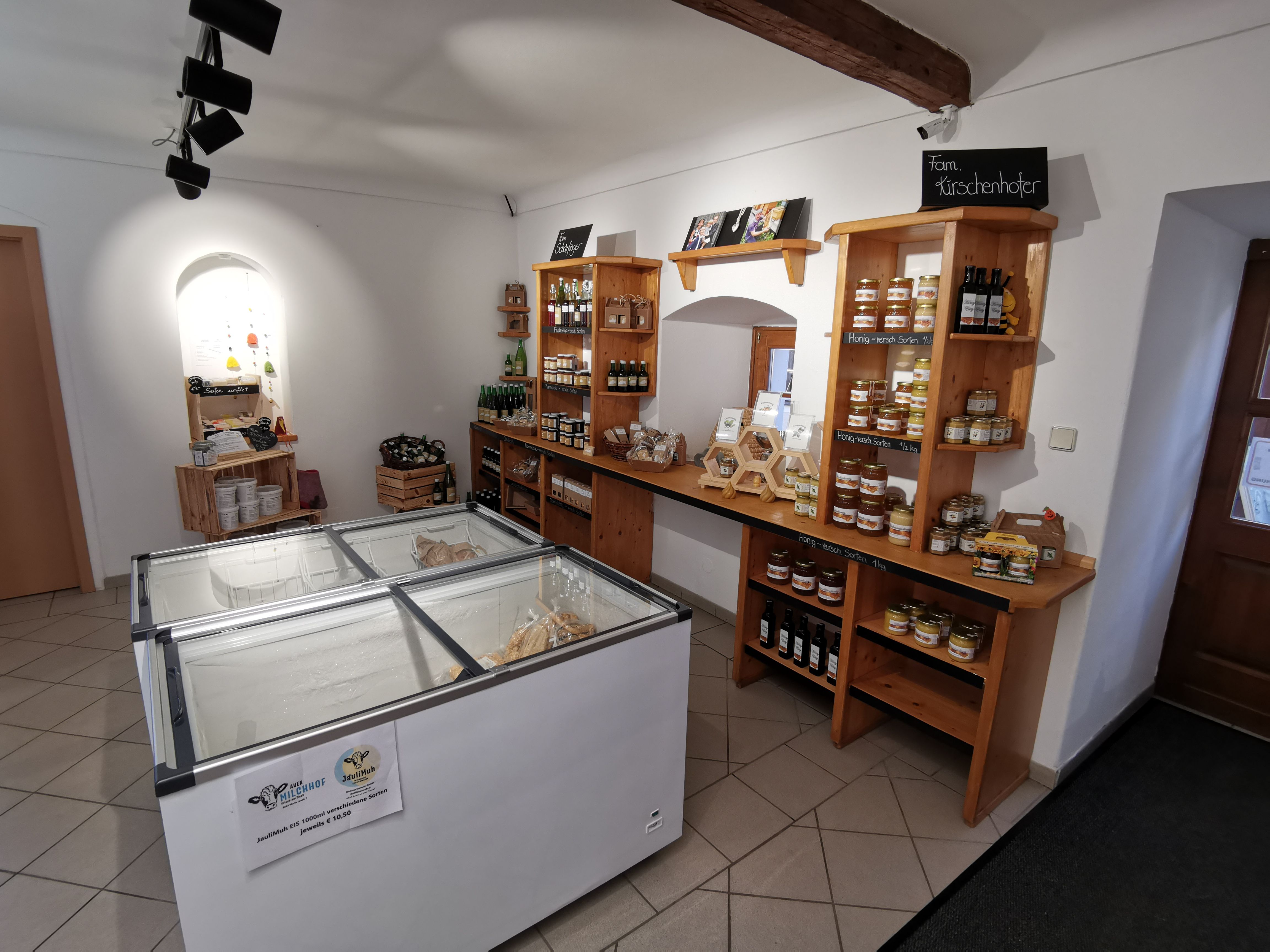 Innenraum des Hofladens mit Kühltruhen und Komoden mit Produkten.